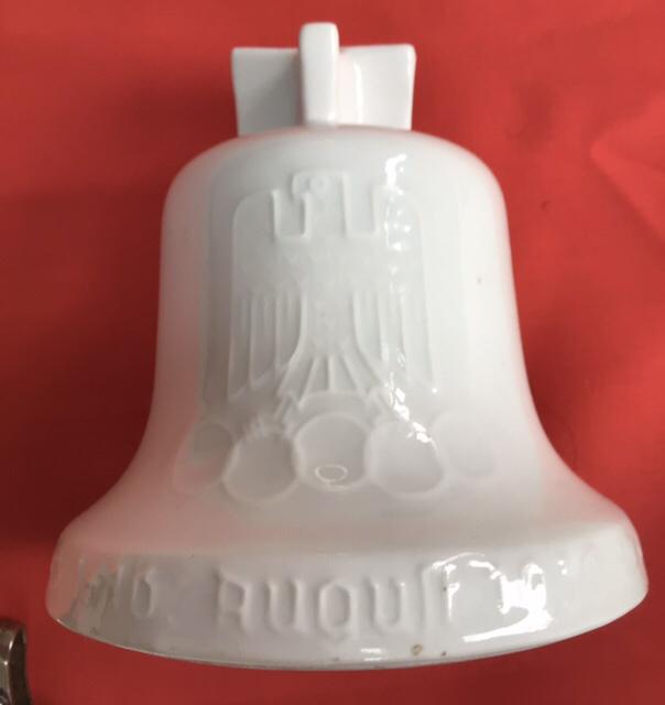 PORCELAIN OLYMPIC BELL MONEY BOX.